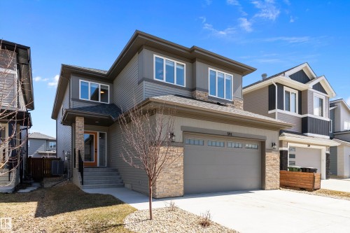 Modern two-story residence featuring a two-car garage, stone accents, and a covered front entry - 591 Boulder Wynd, Leduc, AB - Outdoor With Facade