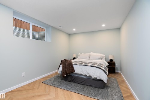 Spacious room featuring light-toned walls, recessed ceiling lighting, and wood-finish flooring with a herringbone pattern - 591 Boulder Wynd, Leduc, AB - Indoor