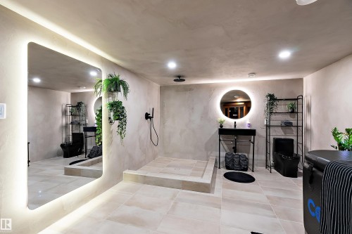 Contemporary bathroom featuring a large illuminated vanity mirror, recessed ceiling lighting, and a walk-in shower with a rainfall showerhead - 591 Boulder Wynd, Leduc, AB - Indoor Photo Showing Other Room