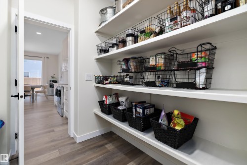 Spacious pantry featuring multiple white shelves, offering extensive storage capacity - 591 Boulder Wynd, Leduc, AB - Indoor Photo Showing Other Room