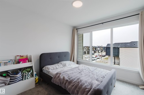 Wall-to-wall carpeting and a large multi-pane window with white trim - 3288 Keswick Way, Edmonton, AB - Indoor Photo Showing Bedroom
