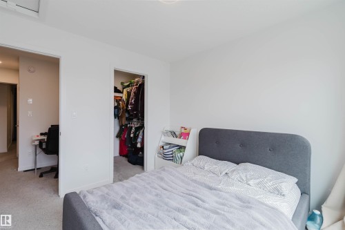 Bedroom with light gray carpeting, crisp white walls, and an open closet featuring a built-in hanging rod - 3288 Keswick Way, Edmonton, AB - Indoor Photo Showing Bedroom