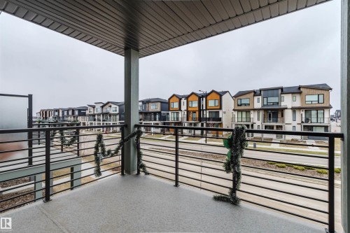 Covered balcony featuring a textured concrete surface and contemporary horizontal metal railings - 3288 Keswick Way, Edmonton, AB - Outdoor With Balcony