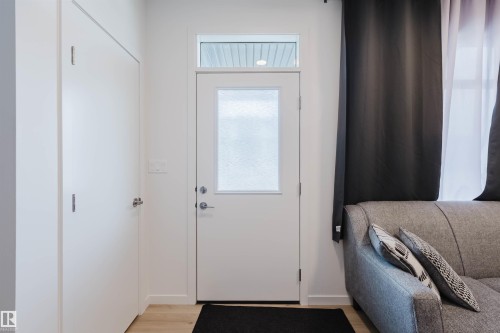 Entryway with a white door featuring a frosted glass panel and transom window - 3288 Keswick Way, Edmonton, AB - Indoor Photo Showing Other Room