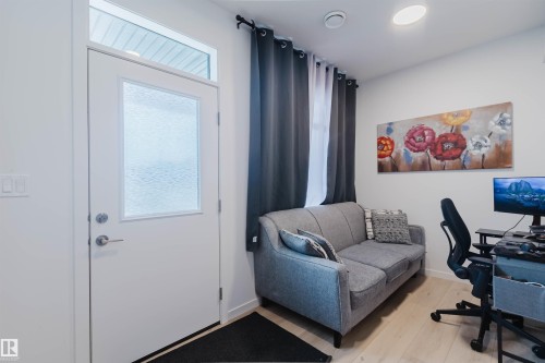 Entry with a frosted glass panel door and transom window, light wood-finish flooring, recessed ceiling lighting, and light-toned walls - 3288 Keswick Way, Edmonton, AB - Indoor Photo Showing Other Room