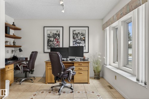 Dedicated workspace featuring multiple workstations, recessed shelving, and a triple window assembly - 848 Wheeler Road W, Edmonton, AB - Indoor Photo Showing Office