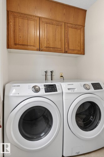 Laundry area featuring wood-finish cabinetry and white walls - 848 Wheeler Road W, Edmonton, AB - Indoor Photo Showing Laundry Room