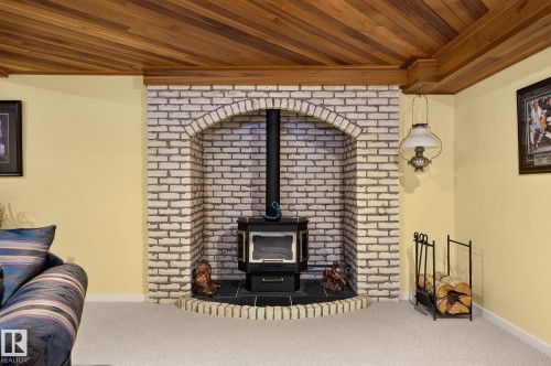Wood plank ceiling with a light wood cornice - 848 Wheeler Road W, Edmonton, AB - Indoor With Fireplace