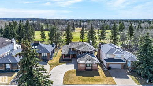 Expansive property featuring a multi-story residence with a paved driveway, mature trees, and a green space backdrop - 848 Wheeler Road W, Edmonton, AB - Outdoor With Facade