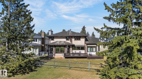 Rear exterior featuring a multi-level deck, stucco finish, multiple windows, and a sunroom with skylights - 848 Wheeler Road W, Edmonton, AB - Outdoor