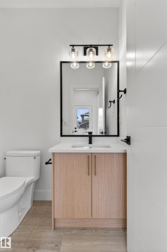 Bathroom vanity with light wood-finish cabinetry, a white countertop, and an undermount sink - 45 River Birch, St. Albert, AB - Indoor Photo Showing Bathroom