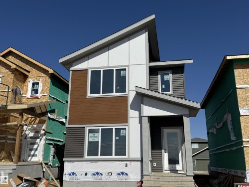 Modern two-story residence featuring a multi-textured facade with brown horizontal siding, gray horizontal siding, and white paneling - 45 River Birch, St. Albert, AB - Outdoor