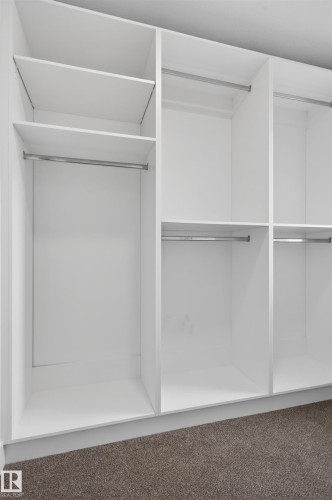 Built-in white cabinetry featuring multiple shelving units and integrated hanging rods - 45 River Birch, St. Albert, AB - Indoor With Storage