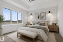 Expansive window with white framing, decorative wall paneling, built-in sconces, tray ceiling detail, and neutral carpeting - 45 River Birch, St. Albert, AB  - Indoor Photo Showing Bedroom 