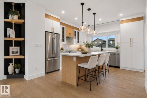 Kitchen featuring wood-finish flooring and an island with a white countertop - 45 River Birch, St. Albert, AB - Indoor Photo Showing Kitchen With Stainless Steel Kitchen With Upgraded Kitchen