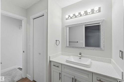 Vanity featuring a rectangular vessel sink, polished chrome faucet, stone-finish countertop, and white shaker-style cabinetry with brushed nickel hardware - 119 Dorchester Drive, St. Albert, AB - Indoor Photo Showing Bathroom