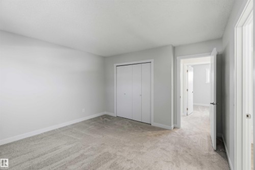 Spacious room featuring light gray wall paint, white trim, gray carpet flooring, and a bifold closet door - 119 Dorchester Drive, St. Albert, AB - Indoor Photo Showing Other Room