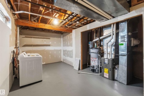 Unfinished basement area featuring painted concrete flooring and exposed ceiling joists - 119 Dorchester Drive, St. Albert, AB - Indoor Photo Showing Laundry Room