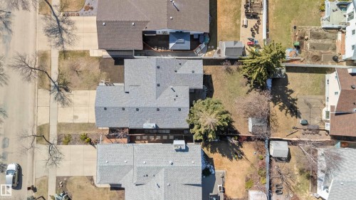Aerial property overview showcasing a gray shingle roof, established trees, and a concrete driveway - 119 Dorchester Drive, St. Albert, AB - Outdoor