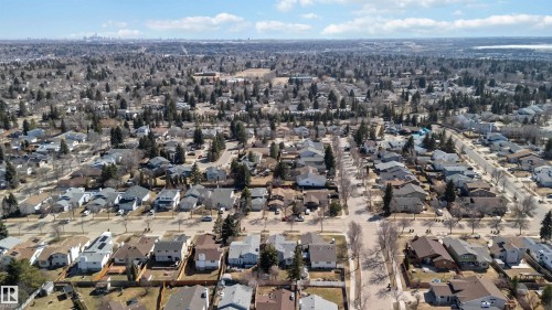 Residential neighborhood featuring mature trees, paved streets, detached homes, and distant city skyline - 119 Dorchester Drive, St. Albert, AB - Outdoor With View