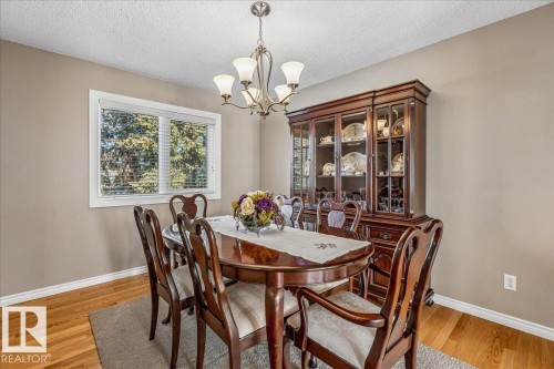 This room features hardwood floors, a window with blinds providing natural light, and a ceiling light fixture - 954 Rice Road, Edmonton, AB - Indoor Photo Showing Dining Room
