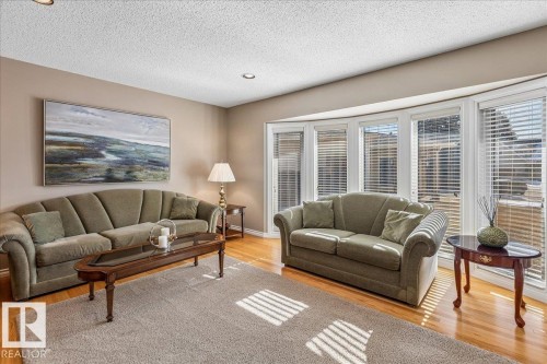 Living area featuring hardwood floors, a bay window with blinds, and recessed lighting - 954 Rice Road, Edmonton, AB - Indoor Photo Showing Living Room