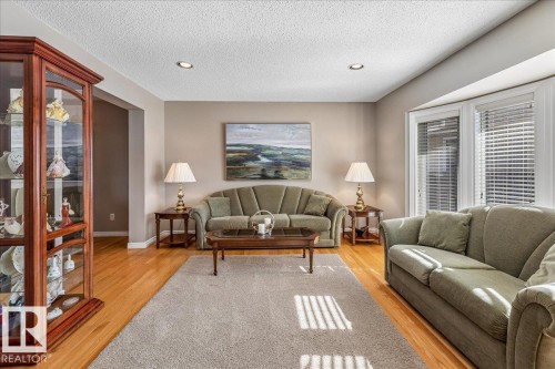 This inviting living area features hardwood floors and a large bay window, providing natural light - 954 Rice Road, Edmonton, AB - Indoor Photo Showing Living Room