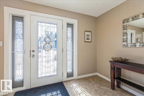 Entryway featuring a white door with decorative glass inserts, flanked by matching sidelight windows, and a tiled floor - 954 Rice Road, Edmonton, AB - Indoor Photo Showing Other Room