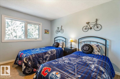 This room features a window with white trim, light blue walls, and carpet flooring - 954 Rice Road, Edmonton, AB - Indoor Photo Showing Bedroom