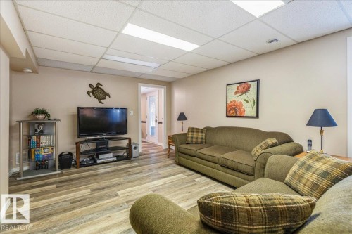 Spacious living area featuring light-toned walls, recessed lighting, and wood-look flooring - 954 Rice Road, Edmonton, AB - Indoor