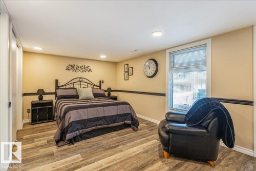This room features wood-look flooring, recessed lighting, and a window with blinds - 954 Rice Road, Edmonton, AB - Indoor Photo Showing Bedroom