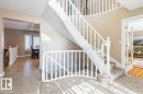 The entryway features a curved staircase with white banisters and carpeted steps - 954 Rice Road, Edmonton, AB  - Indoor Photo Showing Other Room 