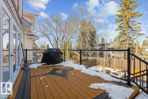 The property features a spacious deck with a two-tone pattern and glass railing, accessible through double doors - 954 Rice Road, Edmonton, AB - Outdoor With Deck Patio Veranda