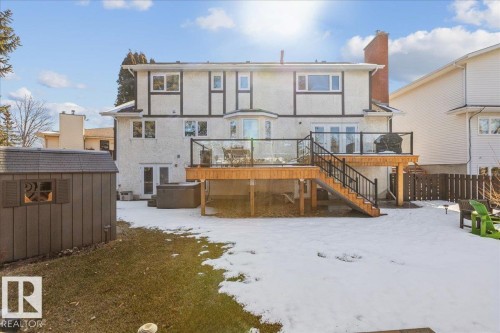 The property features an extensive backyard with a spacious wooden deck, complete with glass panel railings and stairs leading to the yard - 954 Rice Road, Edmonton, AB - Outdoor With Deck Patio Veranda