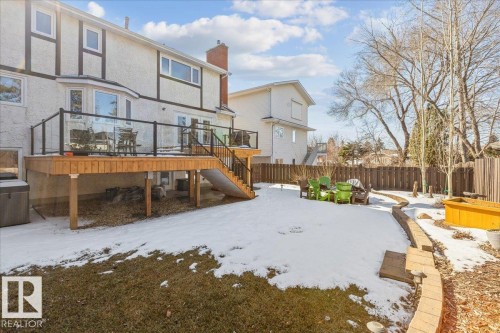 The property features a spacious backyard with a wooden deck and glass railings, accessible via a staircase - 954 Rice Road, Edmonton, AB - Outdoor With Deck Patio Veranda