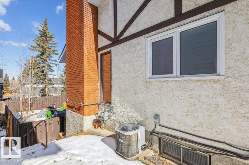 The property features a red brick chimney and stucco exterior with dark trim detailing - 954 Rice Road, Edmonton, AB - Outdoor With Exterior