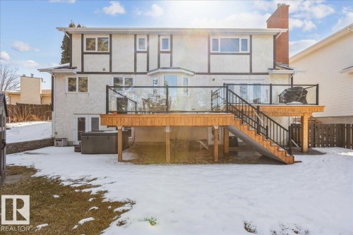The property features a spacious rear deck with glass railings and a staircase leading to the yard - 954 Rice Road, Edmonton, AB - Outdoor