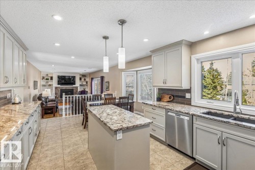 The kitchen features a central island, light-colored cabinetry, and granite countertops - 954 Rice Road, Edmonton, AB - Indoor Photo Showing Kitchen With Upgraded Kitchen