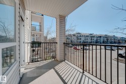 Outdoor balcony featuring a concrete surface, black metal railings, and a siding exterior - 