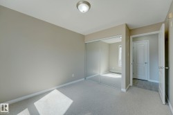 Carpeted room featuring a ceiling-mounted light fixture, neutral wall paint, and white baseboards - 