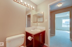 Bathroom vanity featuring a single basin sink, dark wood-finish cabinetry, and a light-toned countertop - 