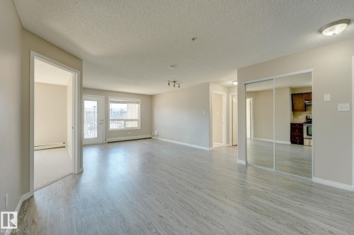Expansive main living area featuring wood-finish flooring and neutral wall tones - 7226 7327 South Terwillegar Drive, Edmonton, AB - Indoor Photo Showing Other Room
