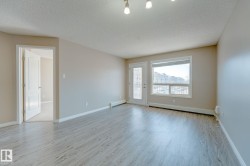 Spacious room featuring wood-finish flooring, neutral-toned walls, and white baseboards - 