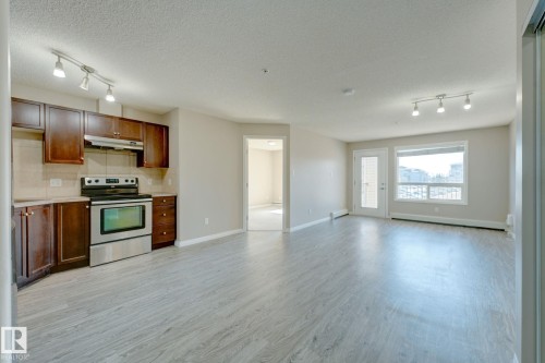 Open-concept living space featuring wood-finish flooring and track lighting - 7226 7327 South Terwillegar Drive, Edmonton, AB - Indoor Photo Showing Kitchen