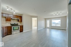 Open-concept living space featuring wood-finish flooring and track lighting - 