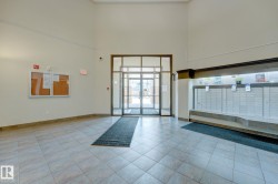 Spacious entry foyer featuring large format tile flooring, a glass-paneled entry door, and a wall of mailboxes - 