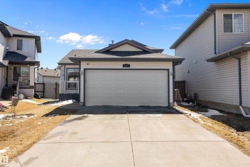 Single-family home featuring a two-car garage, concrete driveway, and light-colored siding - 1811 37 Avenue, Edmonton, AB - Outdoor