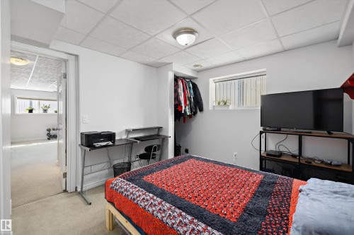 Bedroom with carpet flooring, a drop ceiling, and a wall-mounted light fixture - 1811 37 Avenue, Edmonton, AB - Indoor Photo Showing Bedroom