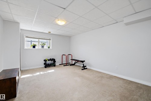 Finished basement space featuring light carpet, neutral walls, and a drop ceiling with recessed lighting - 1811 37 Avenue, Edmonton, AB - Indoor