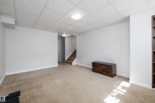 Carpeted lower level with light gray walls and white trim - 1811 37 Avenue, Edmonton, AB - Indoor Photo Showing Other Room